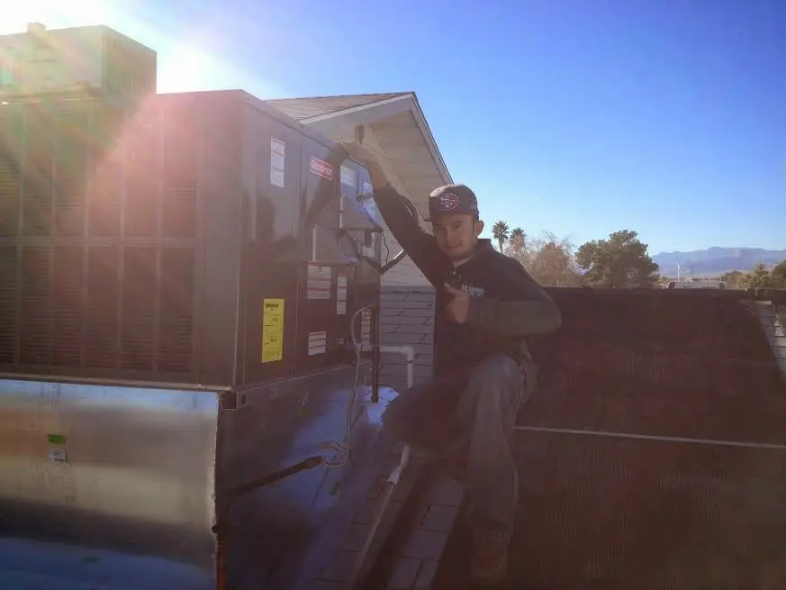 HVAC technician performing HVAC Inspection on a rooftop unit in Columbia